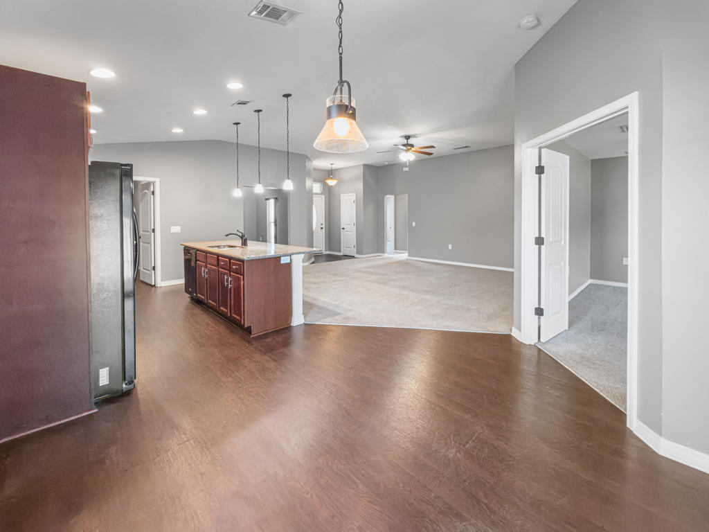 125 Lillian Way Crestview, FL 32536 - Photo 5 of 33 a view of a kitchen with granite countertop a refrigerator oven a sink and a chandelier