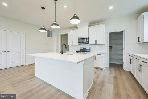 a kitchen with stainless steel appliances a kitchen island hardwood floor sink stove and wooden floor