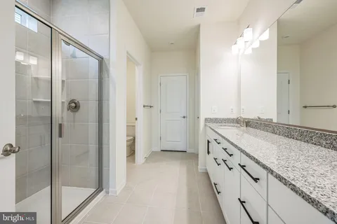 a spacious bathroom with a granite countertop sink mirror and a shower