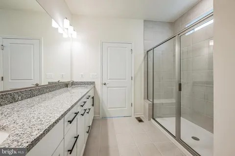 a bathroom with a granite countertop sink a toilet and shower