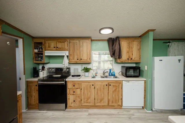 a kitchen with a sink a stove and a refrigerator