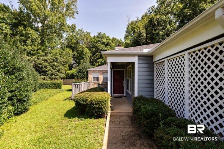 12 Stonebridge Court Mobile, AL 36608 - Photo 24 of 38 View of exterior entry featuring a yard and a chimney