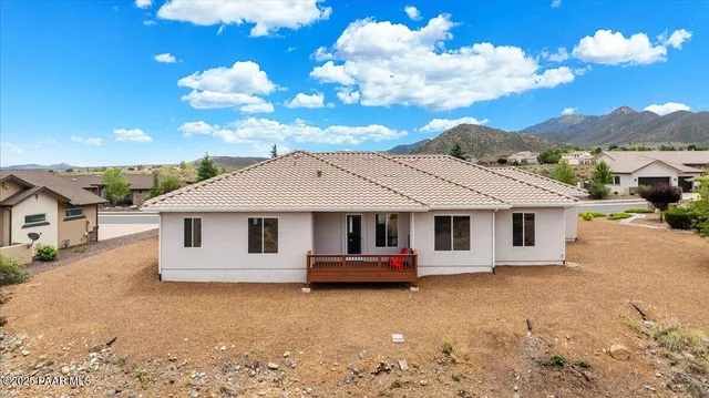 a view of a living room with wooden floor and floor to ceiling window