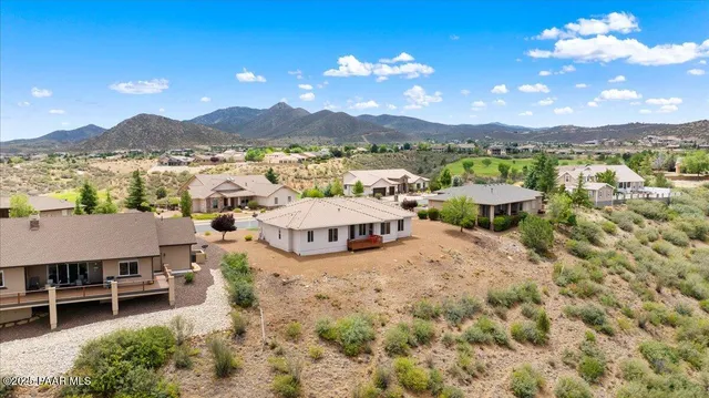a view of a lush green outdoor space with a swimming pool and valleys in the background