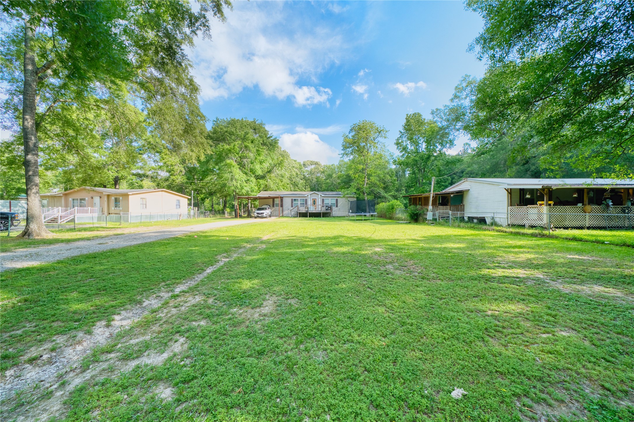 103 County Road 370 Splendora, TX 77372 - Photo 2 of 32 a view of a house with a yard deck and sitting area