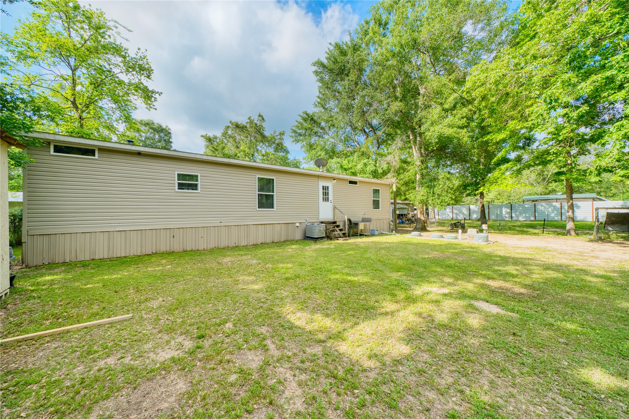 103 County Road 370 Splendora, TX 77372 - Photo 26 of 32 a view of a backyard with plants and large tree
