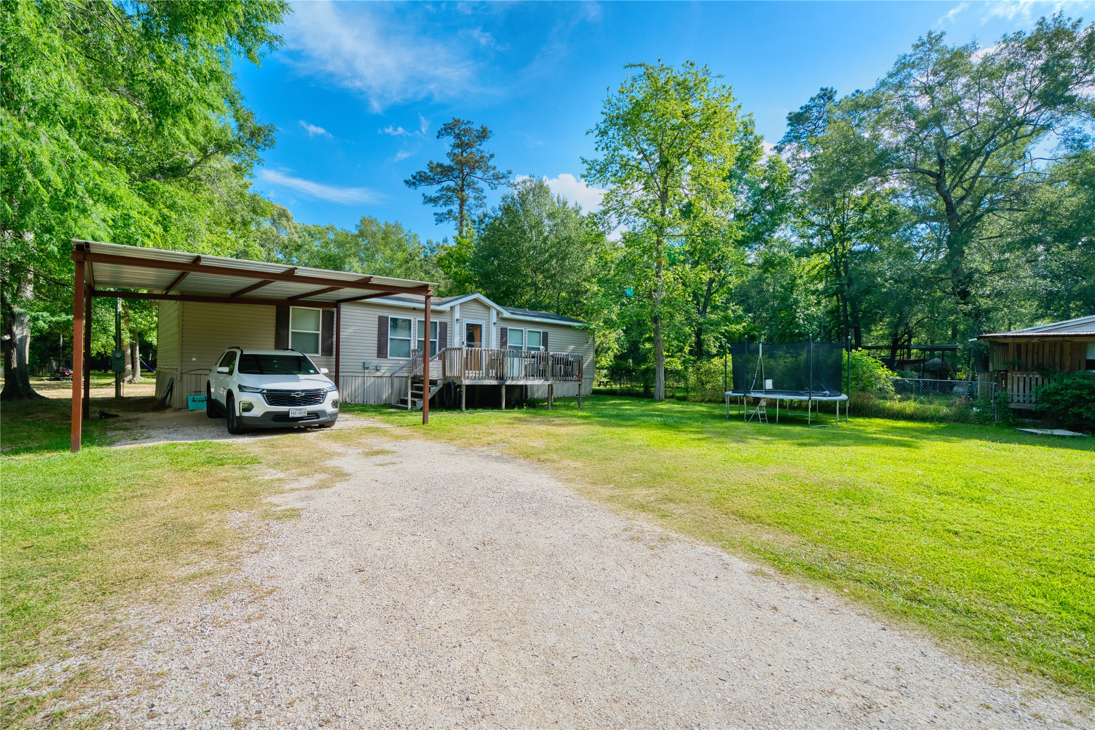 103 County Road 370 Splendora, TX 77372 - Photo 5 of 32 a front view of a house with a garden and trees