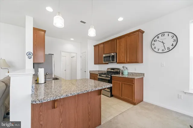a kitchen with granite countertop a stove top oven microwave and cabinets