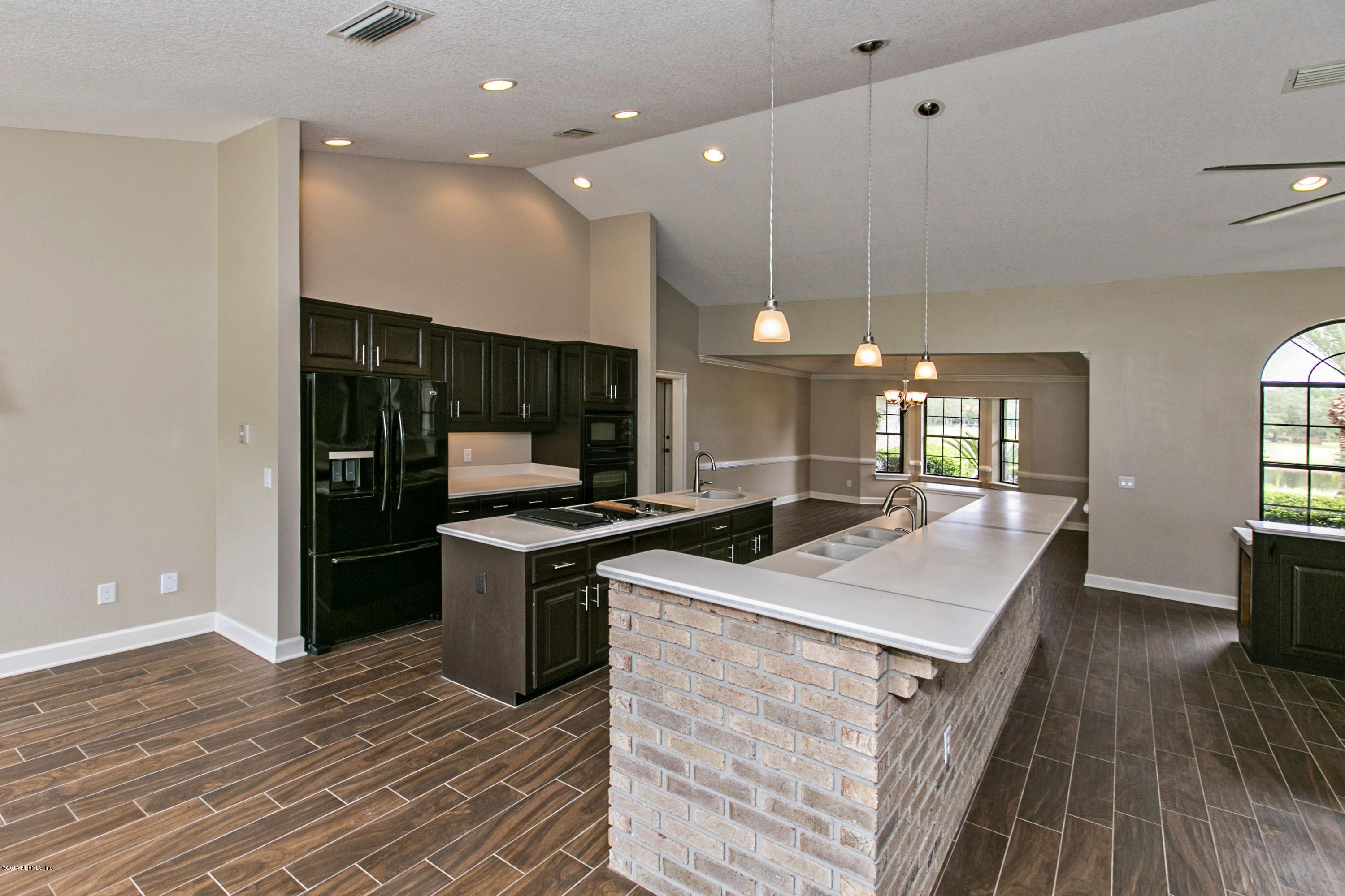 5395 D Church Road St. Augustine, FL 32092 - Photo 11 of 27 a kitchen with stainless steel appliances granite countertop a sink a stove and a wooden floors