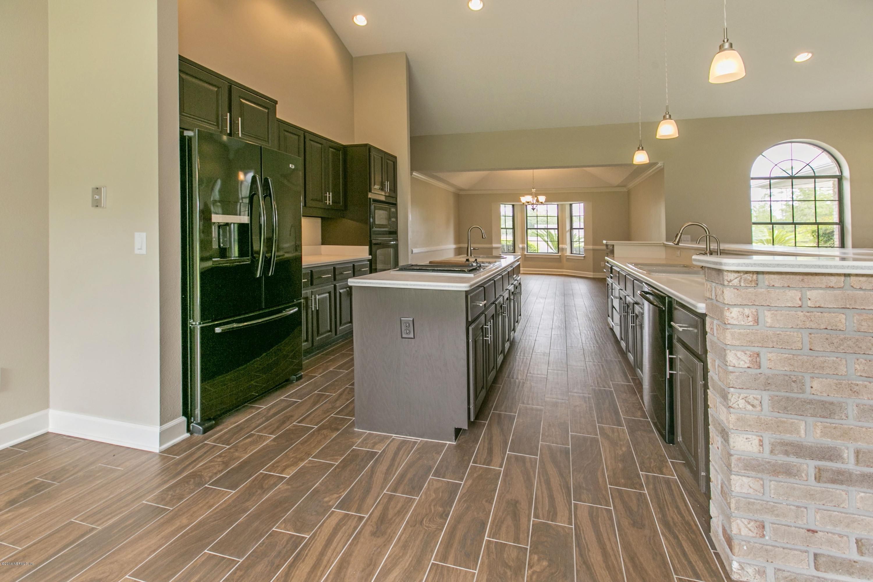 5395 D Church Road St. Augustine, FL 32092 - Photo 12 of 27 a large kitchen with stainless steel appliances granite countertop a stove and a wooden floors