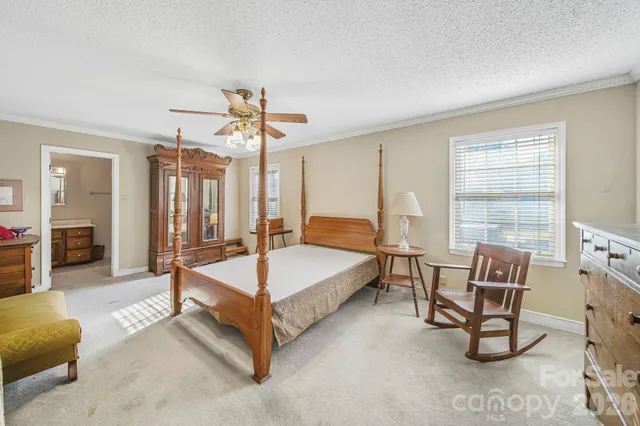 a spacious bedroom with a bed a couch and dresser