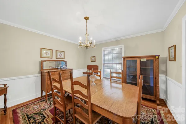 a dining room with furniture a chandelier and wooden floor