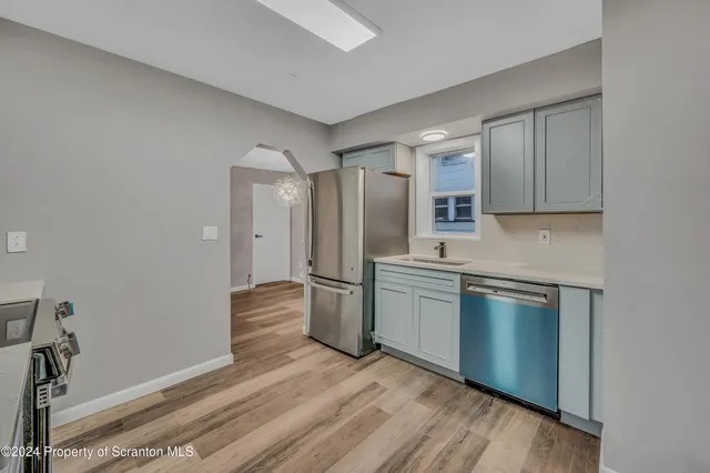 a kitchen with stainless steel appliances granite countertop a refrigerator and a stove top oven