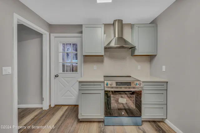 a kitchen with white cabinets and a stove