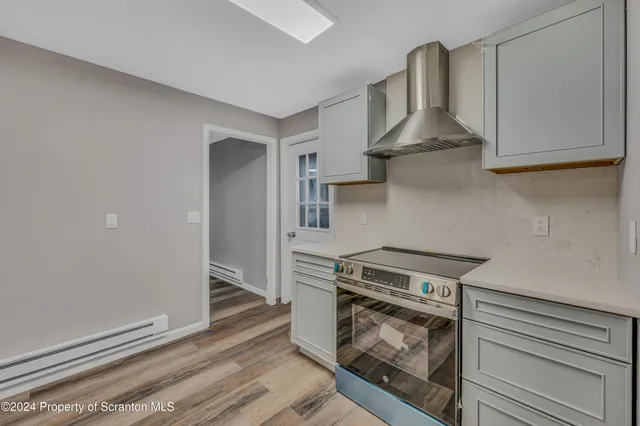 a kitchen with white cabinets and a stove