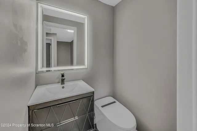 a bathroom with a toilet sink and mirror