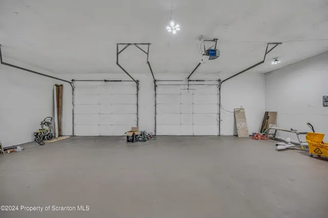 an empty room with ceiling fan and windows
