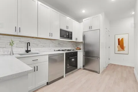 a kitchen with stainless steel appliances a refrigerator sink and cabinets