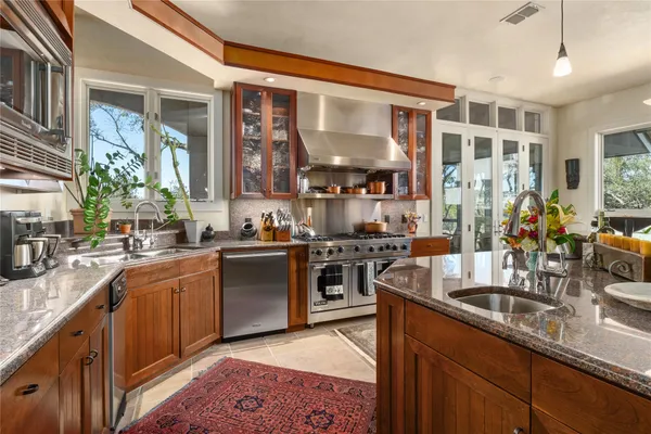 a kitchen with stainless steel appliances granite countertop a sink stove and refrigerator