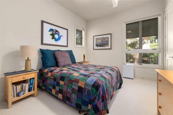 a bedroom with a bed a wall painting and window