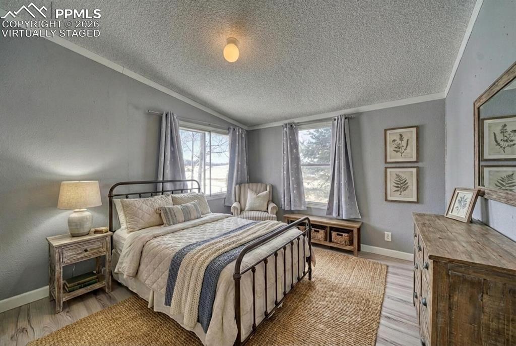 36 Valley Circle Guffey, CO 80820 - Photo 9 of 29 a bedroom with a large bed a chandelier and windows