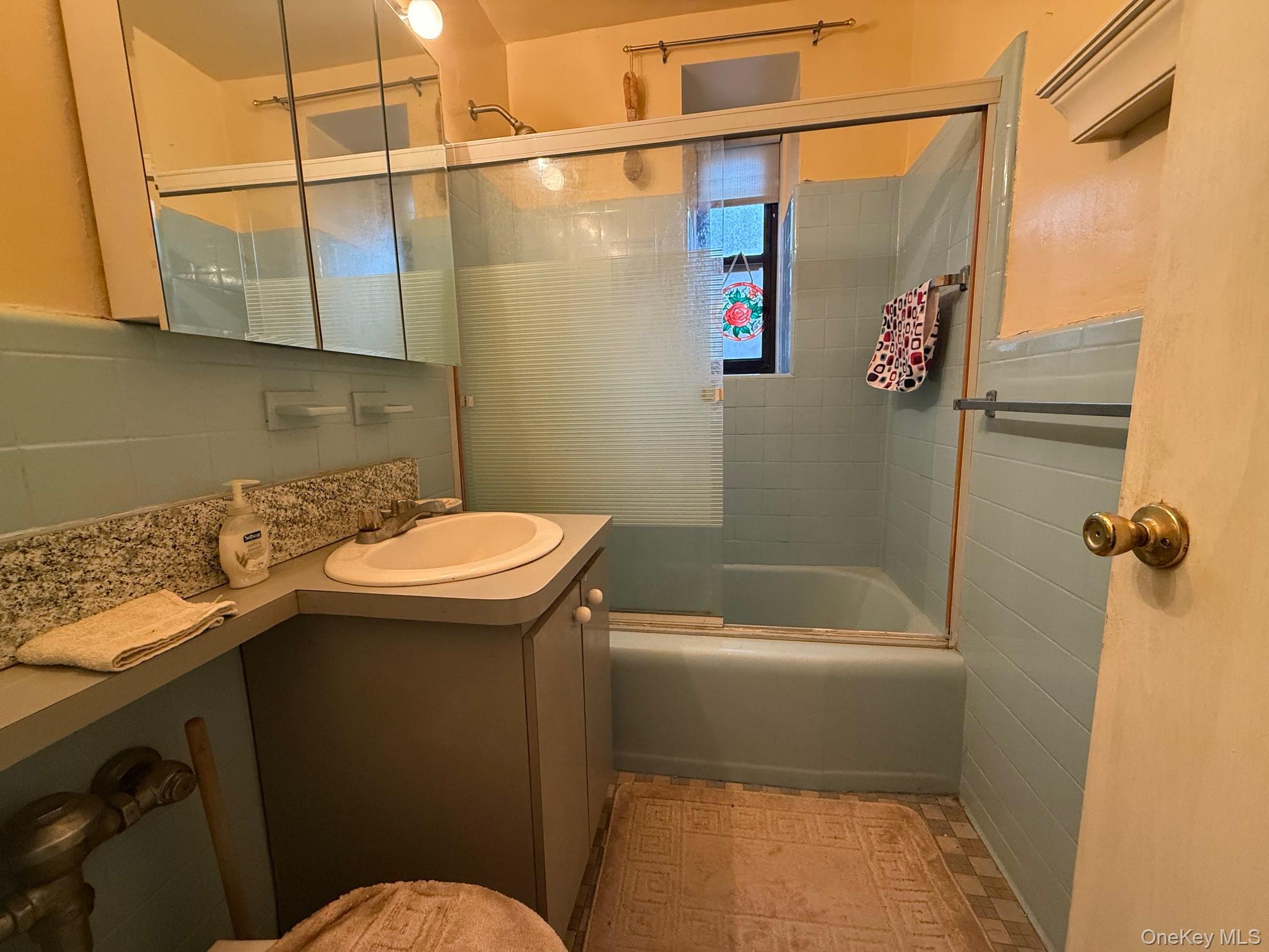 83-25 98th Street, Unit 3B Queens, NY 11421 - Photo 8 of 8 a bathroom with a sink a toilet and shower