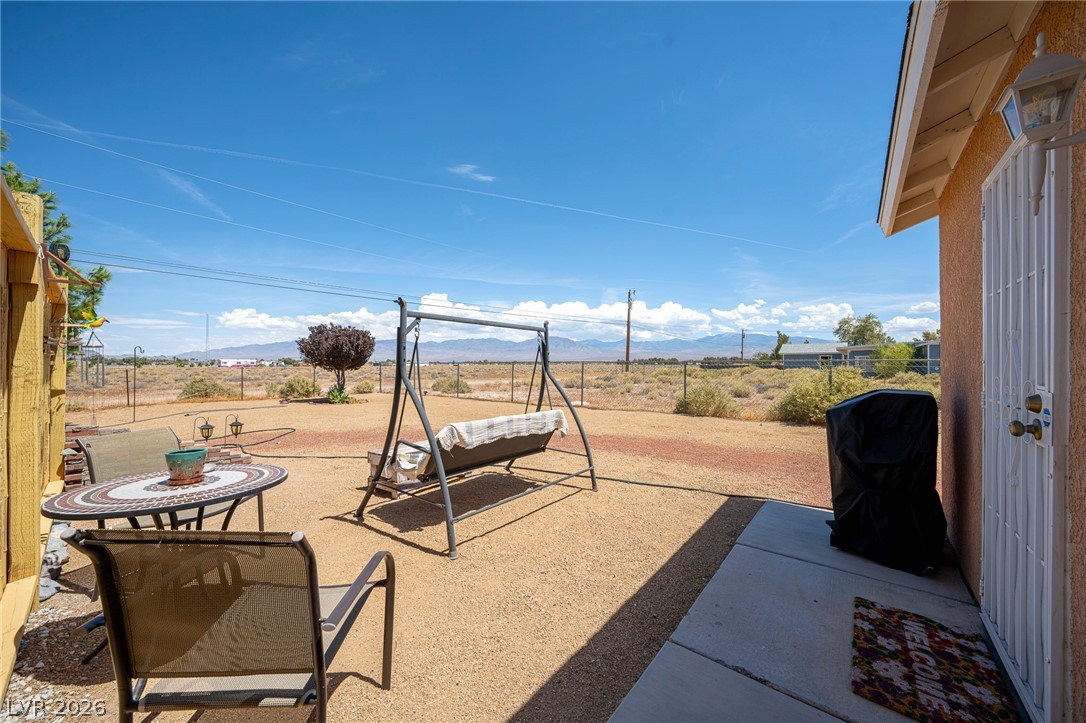 2970 Rio Rico Drive Pahrump, NV 89048 - Photo 25 of 41 A concrete patio extends toward an open yard displaying long distance mountain views.