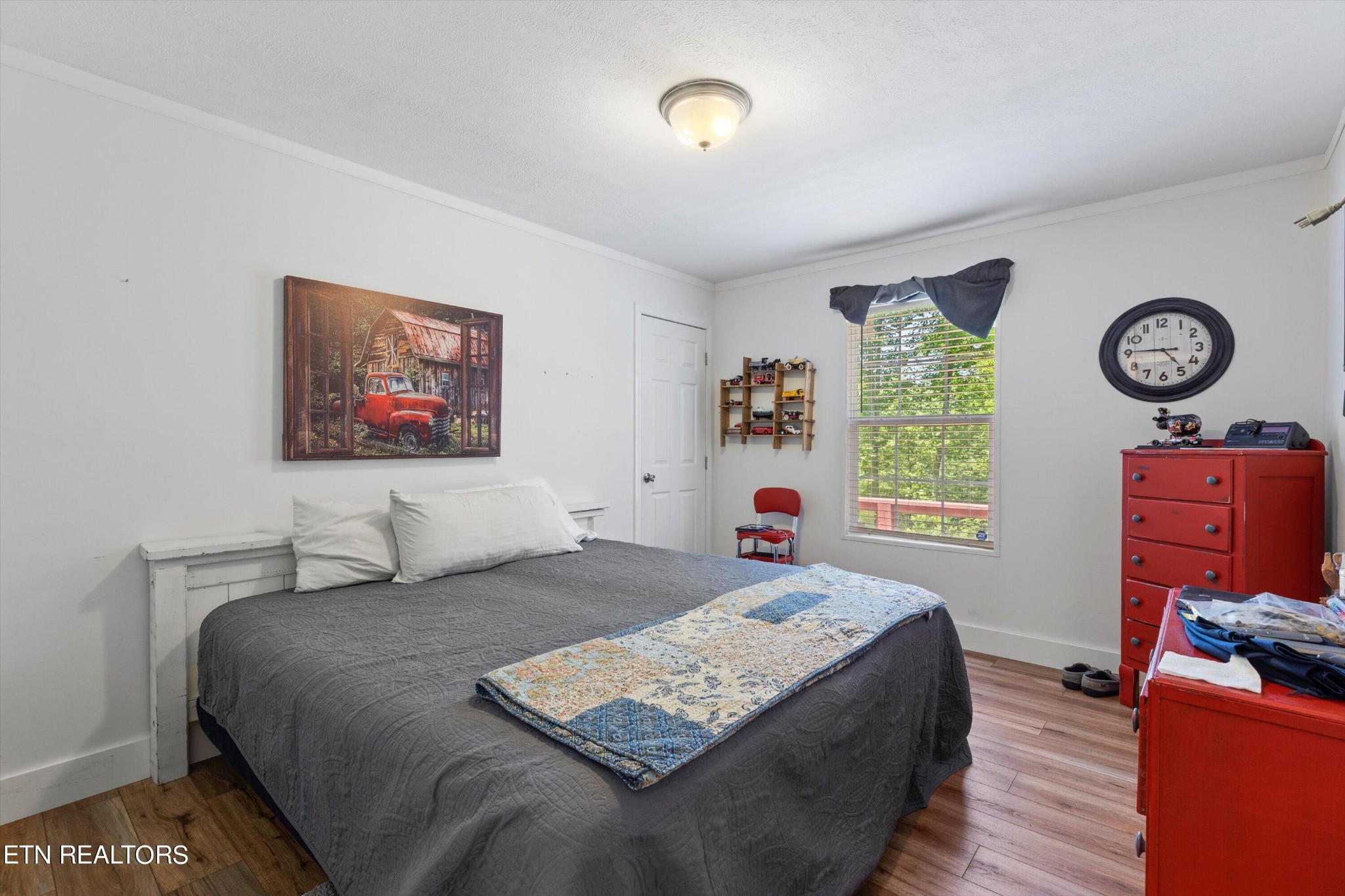 180 Greasy Cove Road Cosby, TN 37722 - Photo 23 of 28 a bedroom with a bed and a bookshelf with wooden floor