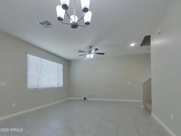 an empty room with windows and a kitchen