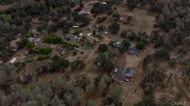 an aerial view of house with yard and mountain view in back