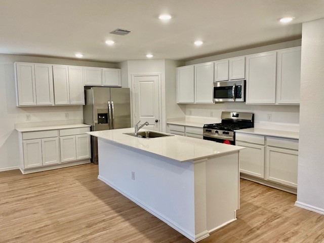 18646 Gravago Lane New Caney, TX 77357 - Photo 16 of 21 a kitchen with kitchen island white cabinets and stainless steel appliances