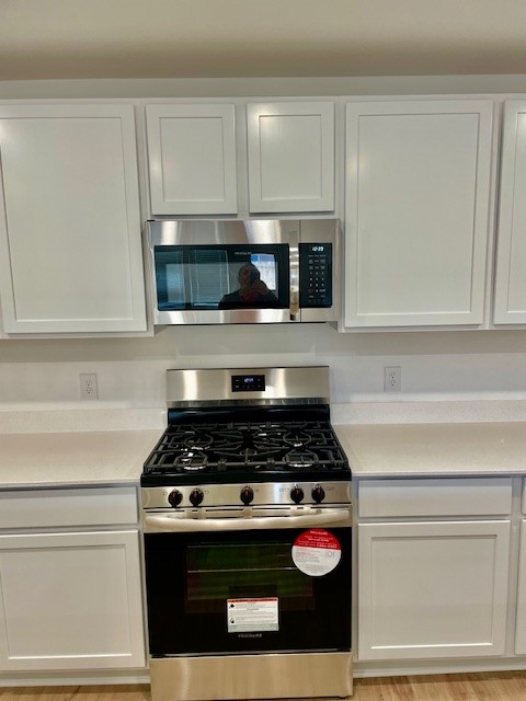 18646 Gravago Lane New Caney, TX 77357 - Photo 20 of 21 a kitchen with white cabinets and appliances