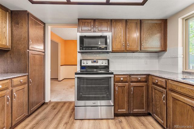 a kitchen with granite countertop wooden cabinets and stainless steel appliances
