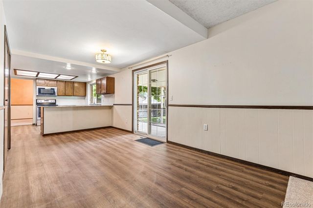 a view of a kitchen with a sink and dishwasher a refrigerator with wooden floor