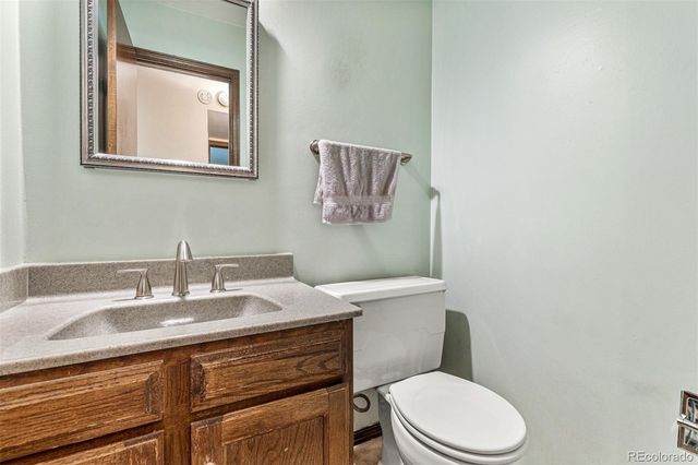 a bathroom with a granite countertop toilet sink and mirror