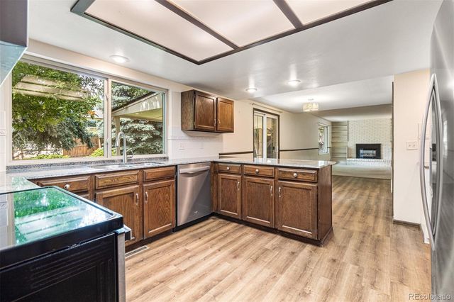 a kitchen with granite countertop a stove a sink and a refrigerator