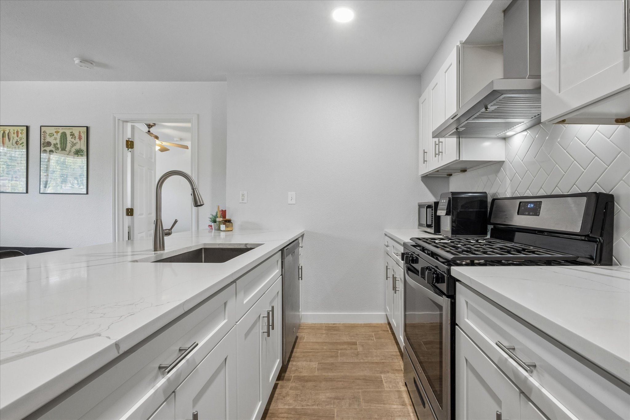 304 East 33rd Street, Unit 4 Austin, TX 78705 - Photo 8 of 15 kitchen features a stunning flatted quart countertop, giving ample space for meal prep, popular white custom cabinetry, tile backsplash wall, deep sink with a modern spray-head faucet, Sink and stove are renovated not attach to walls