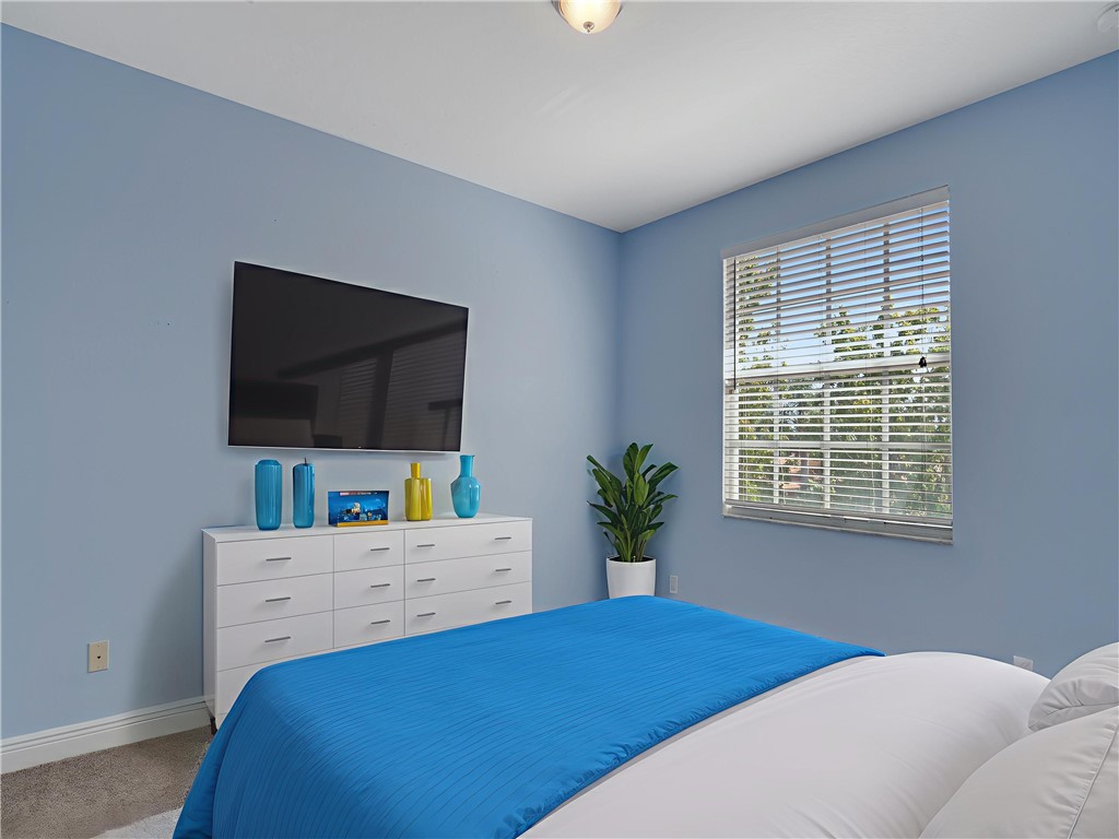 1923 Grey Falcon Circle Southwest Vero Beach, FL 32962 - Photo 17 of 36 a bedroom with a bed and a flat screen tv