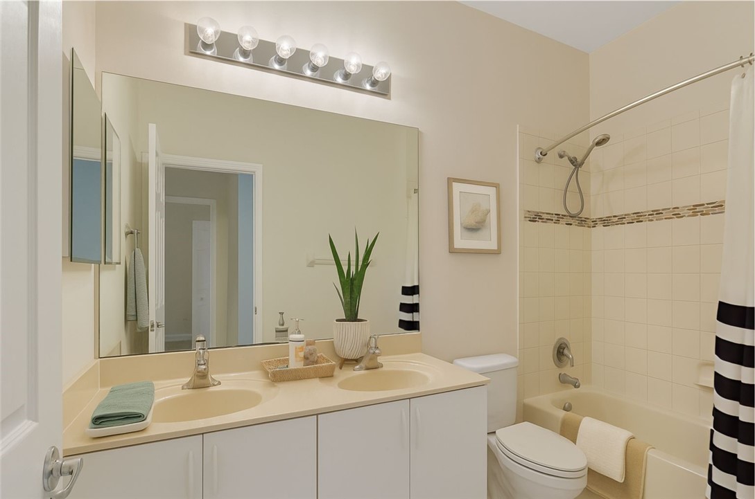 1923 Grey Falcon Circle Southwest Vero Beach, FL 32962 - Photo 18 of 36 a bathroom with a sink a toilet a mirror a vanity and shower