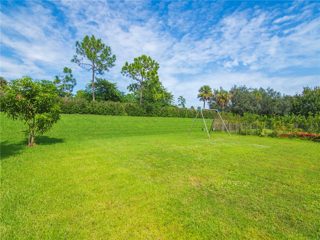 1923 Grey Falcon Circle Southwest Vero Beach, FL 32962 - Photo 24 of 36 a view of a big yard with a large tree