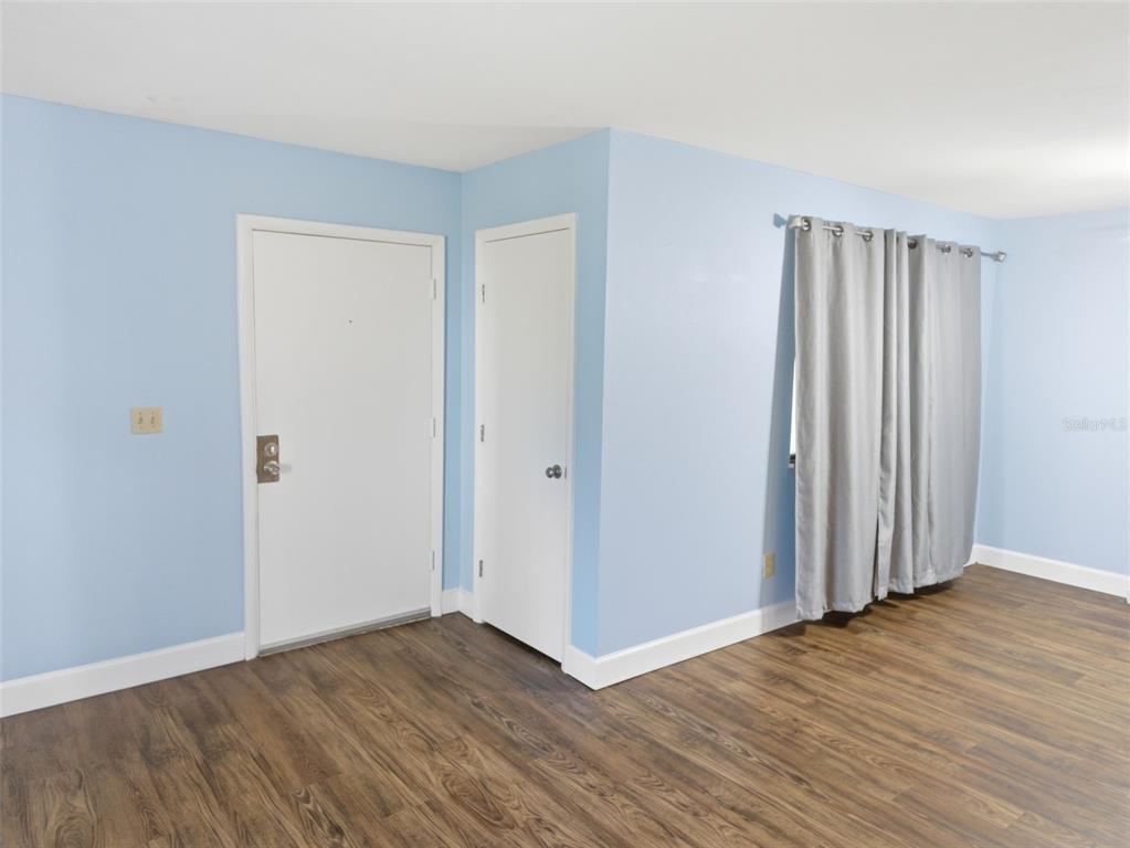 6519 West Newberry Road, Unit 1006 Gainesville, FL 32605 - Photo 4 of 31 a view of an empty room with wooden floor and closet