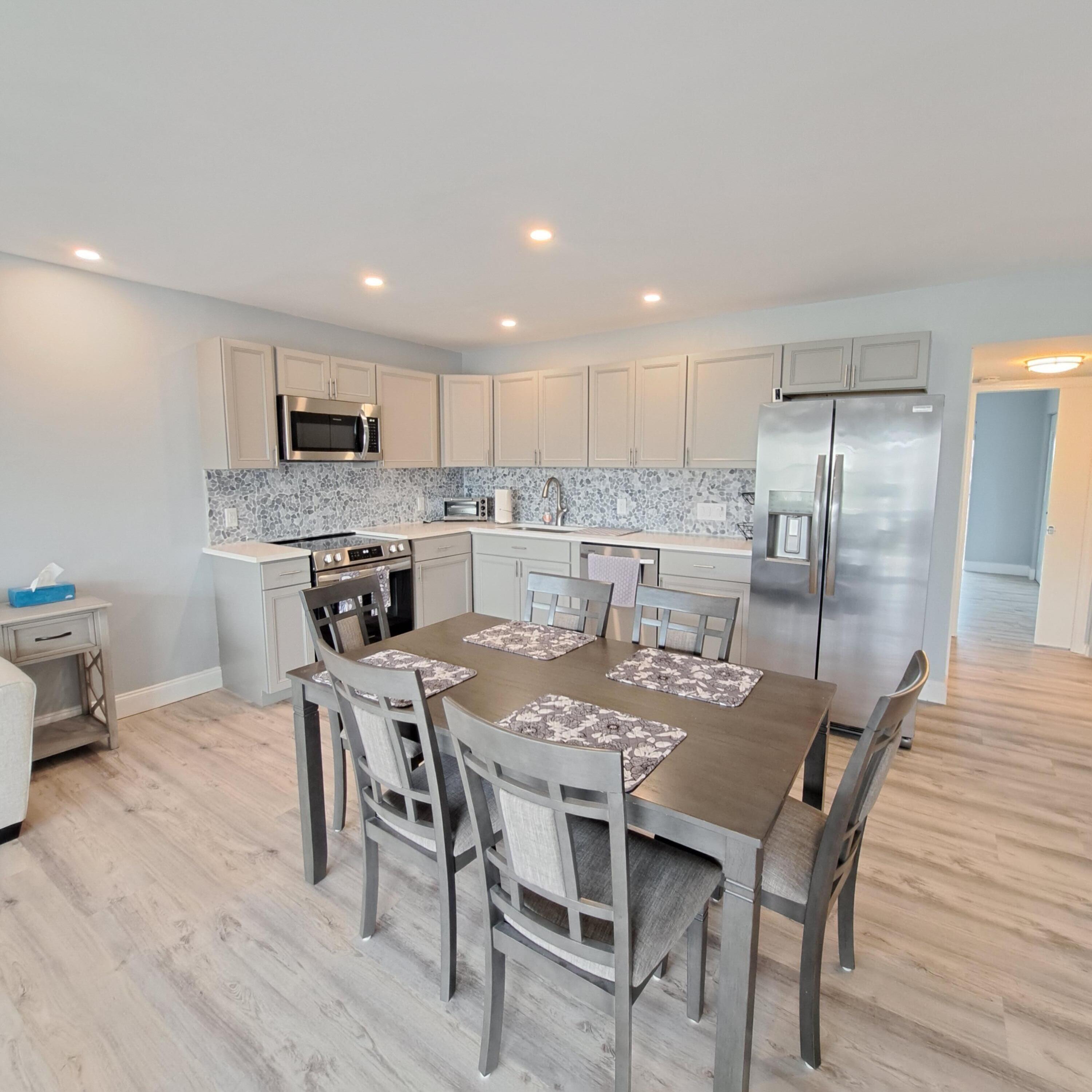 55 Northampton C West Palm Beach, FL 33417 - Photo 3 of 14 a kitchen with kitchen island a dining table and chairs