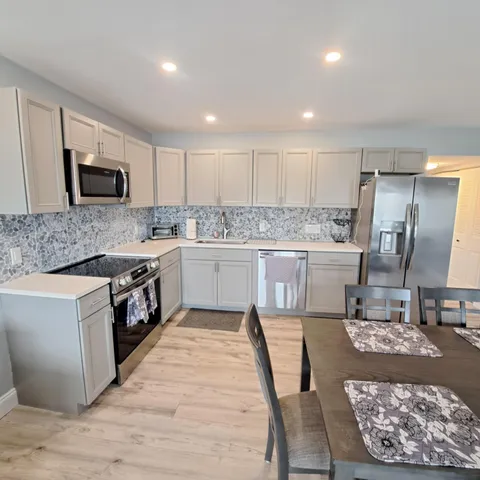 a kitchen with kitchen island a dining table and chairs