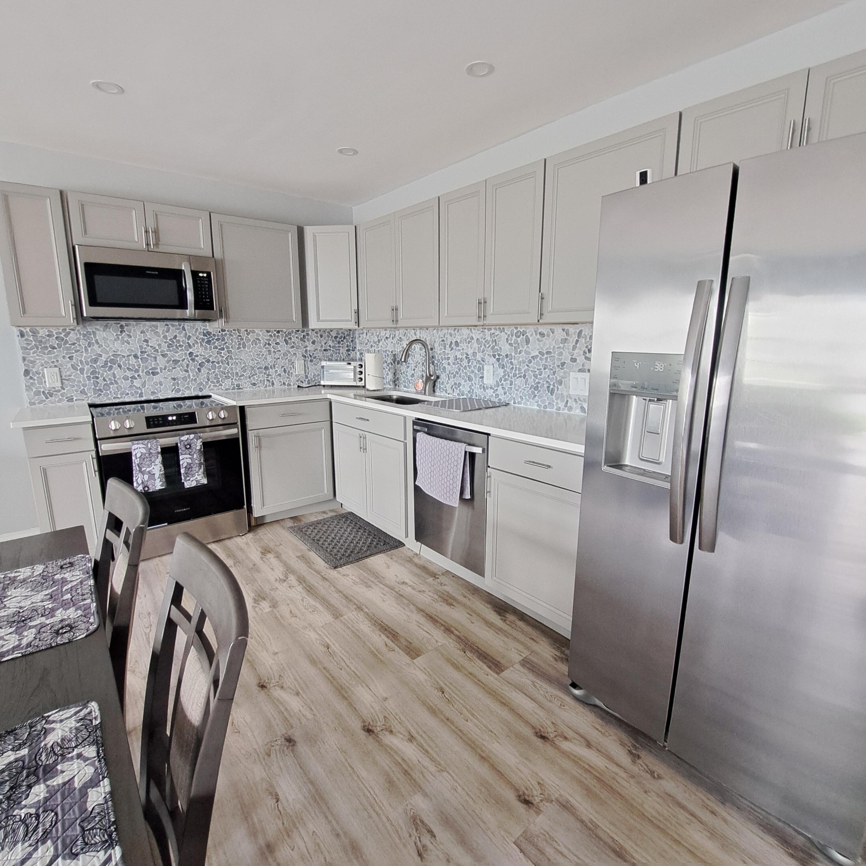 55 Northampton C West Palm Beach, FL 33417 - Photo 5 of 14 a kitchen with stainless steel appliances granite countertop a refrigerator a stove and a sink