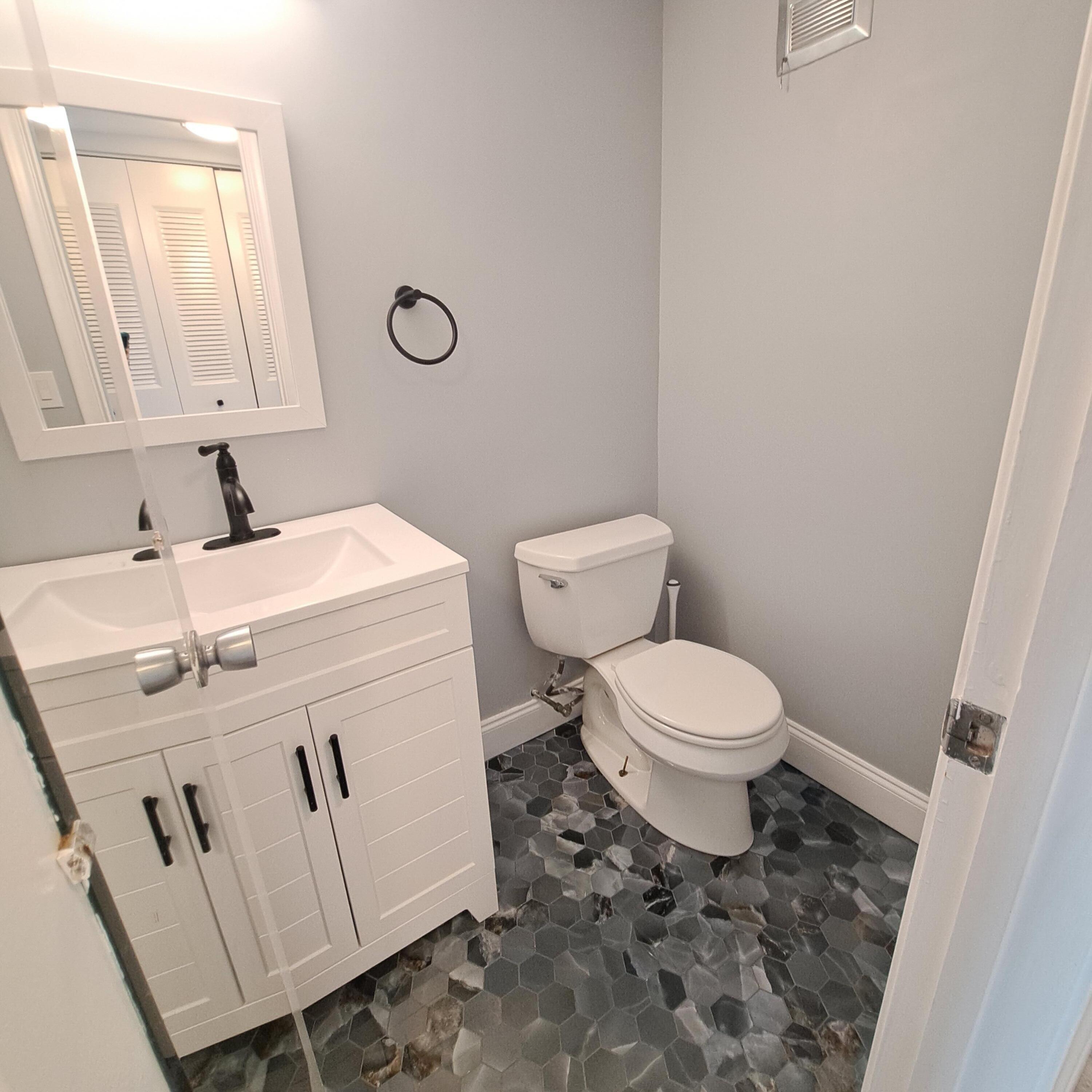 55 Northampton C West Palm Beach, FL 33417 - Photo 6 of 14 a bathroom with a toilet sink and mirror