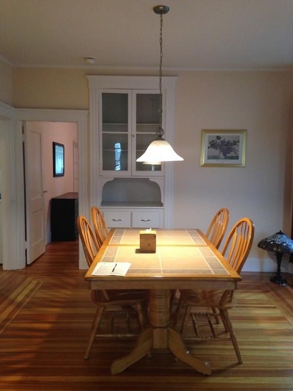 a kitchen with a table chairs and a wooden floor