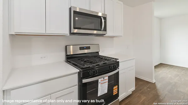 a kitchen with granite countertop a stove and a microwave