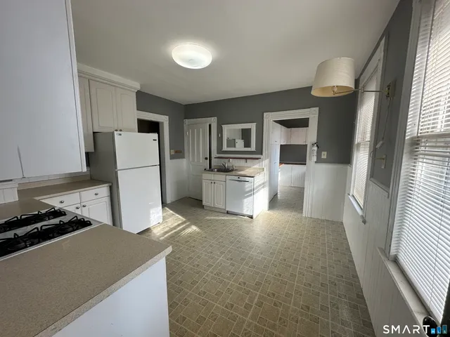 a kitchen with a refrigerator a stove top oven a counter space and a window