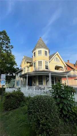 a front view of a house with a yard and potted plants