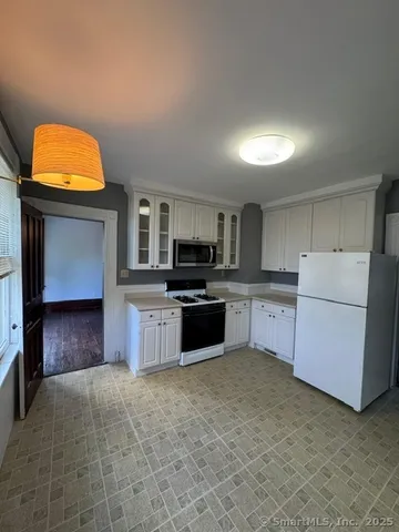a kitchen with stainless steel appliances a stove top oven a sink and a refrigerator